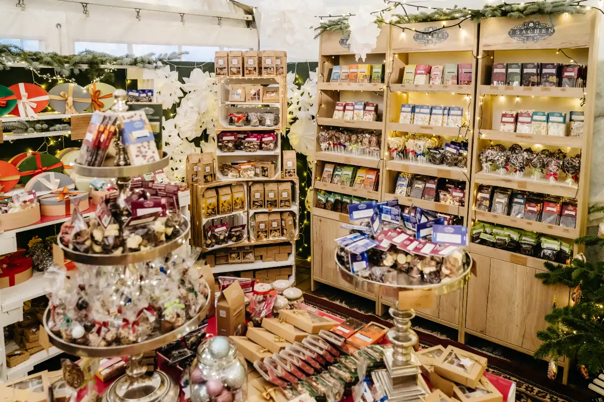 Weihnachtlich dekorierter Verkaufsstand der 7 Sachen Manufaktur mit Pralinen, Schokoladen und Keksen beim Weihnachtszauber Schloss Bückeburg 2022.