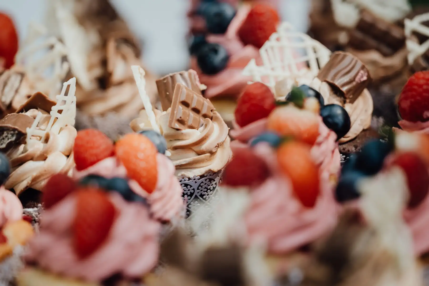 Cupcakes mit Beeren und Schokolade – 7 Sachen Manufaktur Detailaufnahme kunstvoll dekorierter Cupcakes mit frischen Beeren, Schokolade und Baiser – handgefertigt in der 7 Sachen Manufaktur Steinhagen.