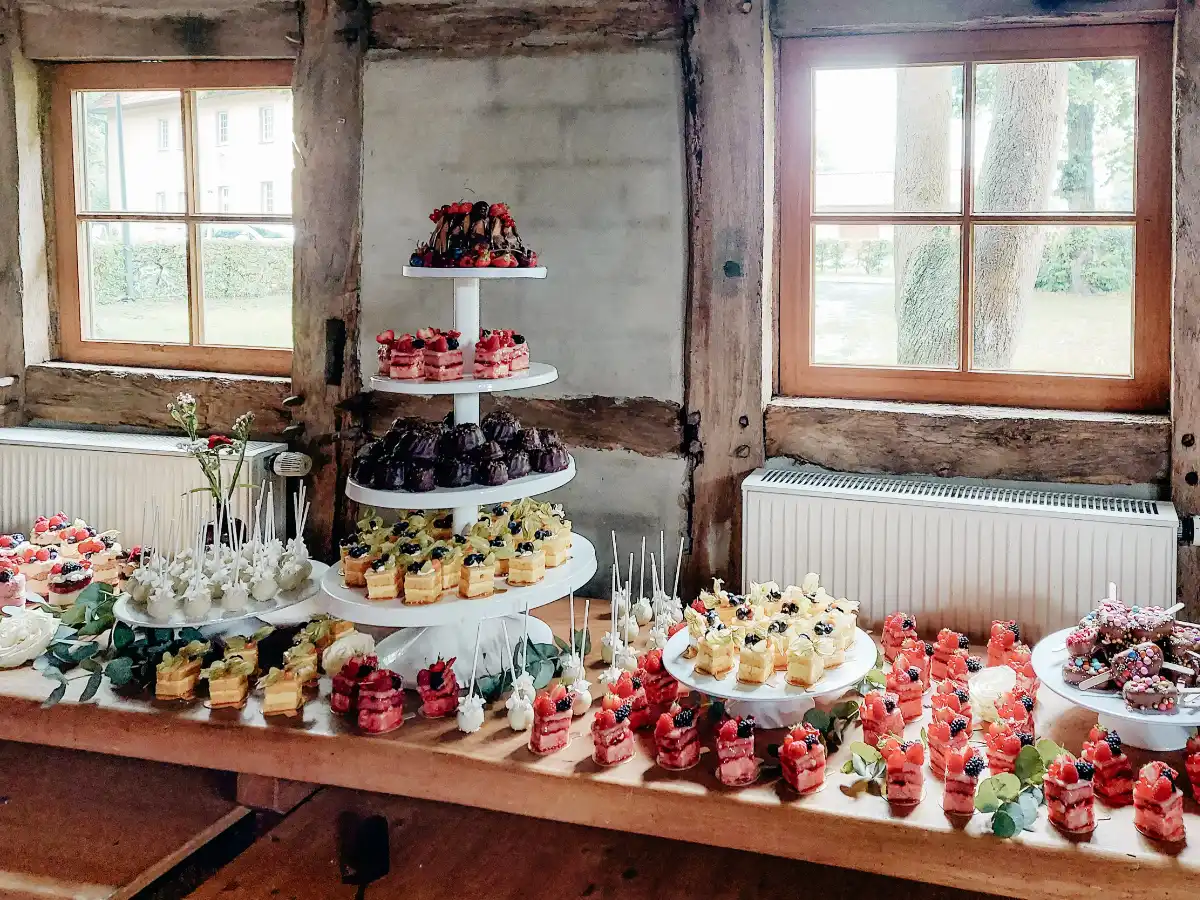 Buffet mit kleinen Törtchen, Mini-Gugelhupf, Cake Pops und Beeren, dekoriert für Hochzeit oder Event von 7 Sachen Manufaktur.