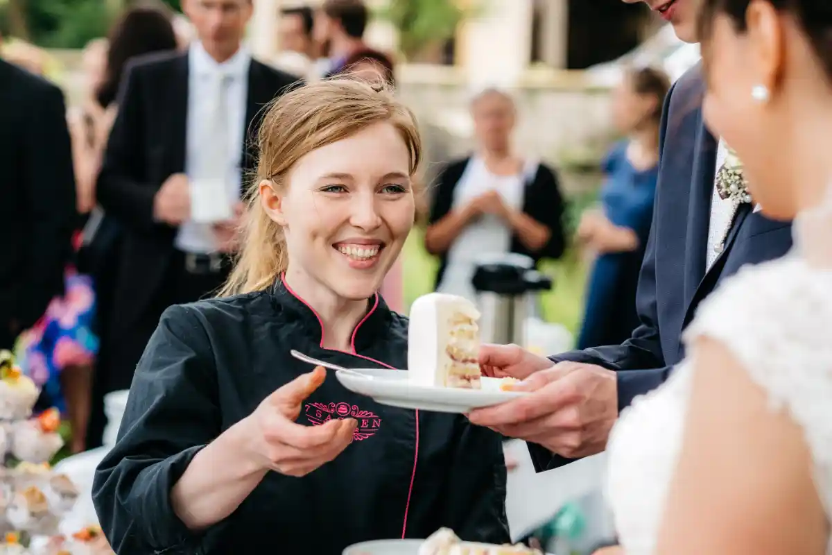 Konditormeisterin Luise Strothenke serviert Tortenstück bei einer Feier, persönlicher Service vor Ort für Events und Firmenfeiern.