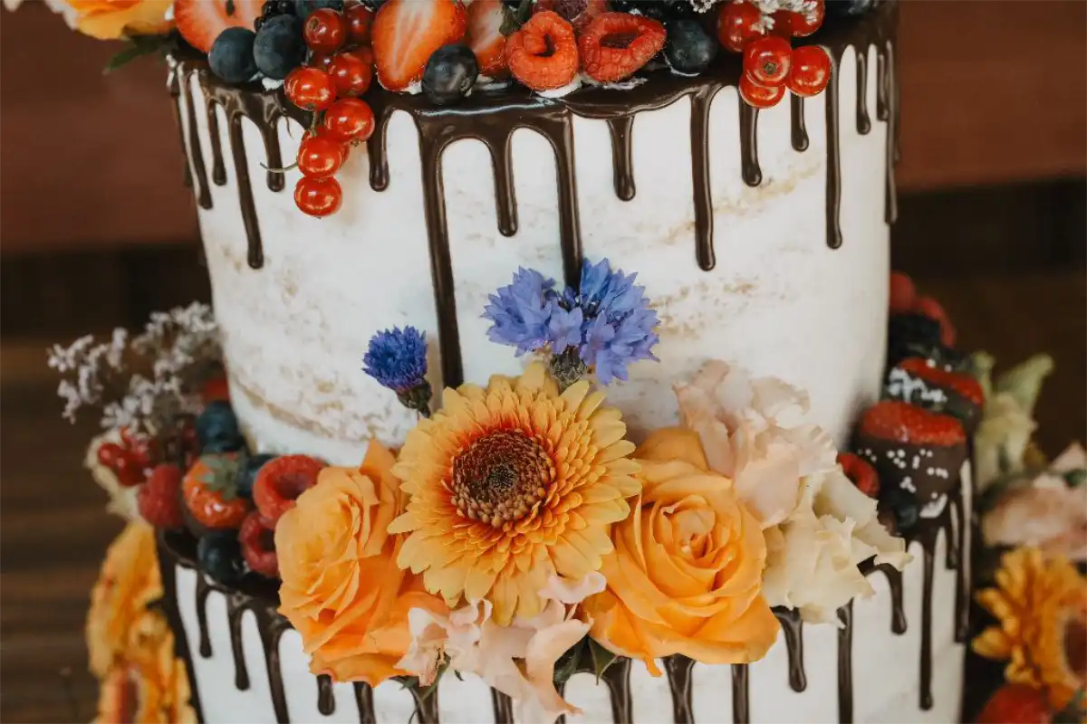 Detailaufnahme Hochzeitstorte mit Schokodrip, frischen Beeren und Blüten Detailaufnahme Semi Naked Hochzeitstorte mit Schokodrip, frischen Beeren und Blüten, angefertigt von 7 Sachen Manufaktur in Oerlinghausen.