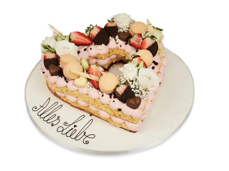 Herztorte „Alles Liebe“ mit rosa Creme, frischen Erdbeeren, Macarons und Schokoladendekor, handgefertigt von 7 Sachen Manufaktur.