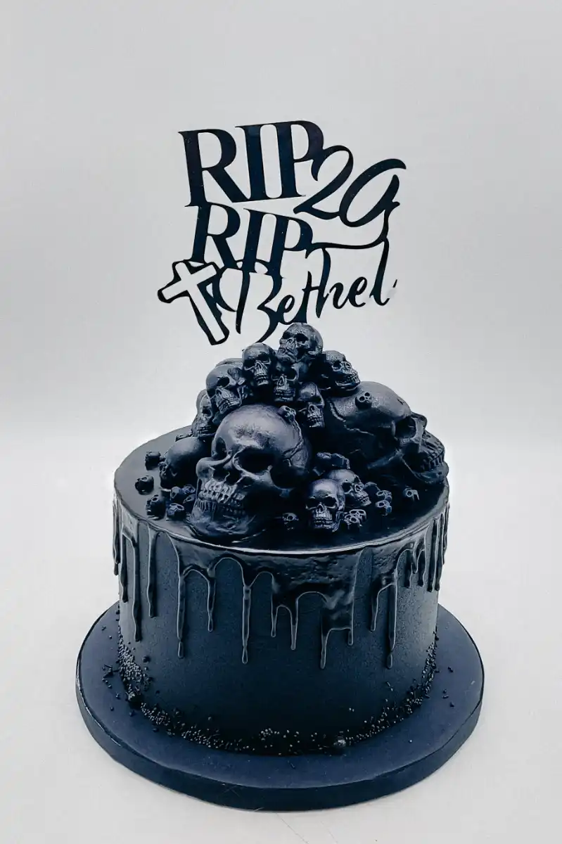 Schwarze Eventtorte mit Totenköpfen, Drip-Dekoration und RIP Cake Topper – moderne Motto-Torte