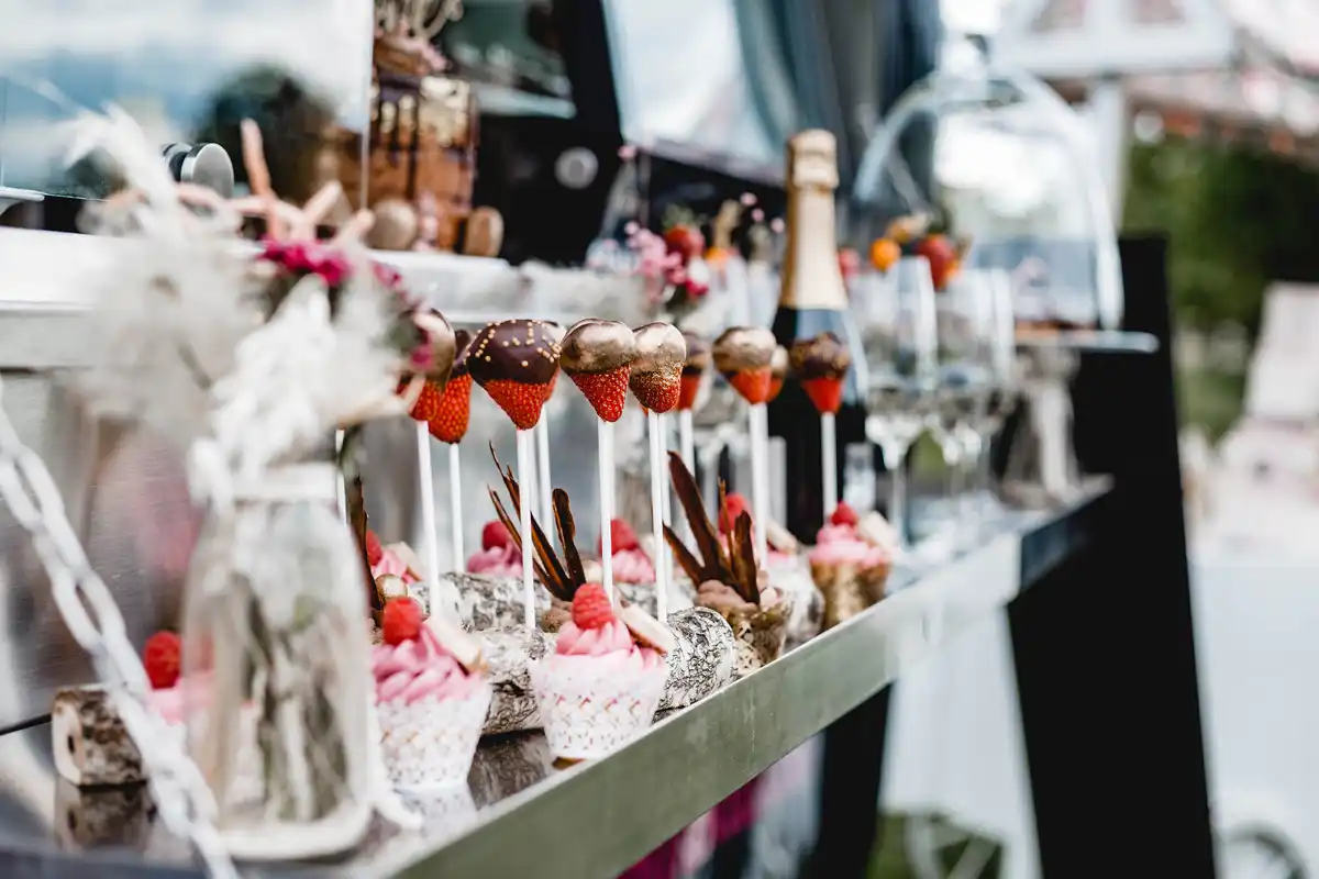 Elegante Dessert-Auswahl mit Cupcakes, Erdbeeren am Stiel mit Schokoladenüberzug und Champagner – stilvoll angerichtet am Foodtruck der 7 Sachen Manufaktur.